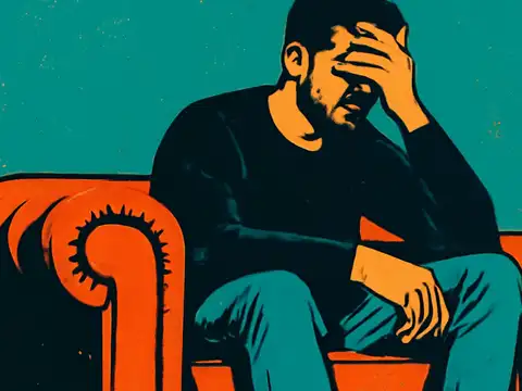 A bearded person sits forward in an armchair with one hand covering their forehead and eyes, rendered as a flat teal and orange illustration.