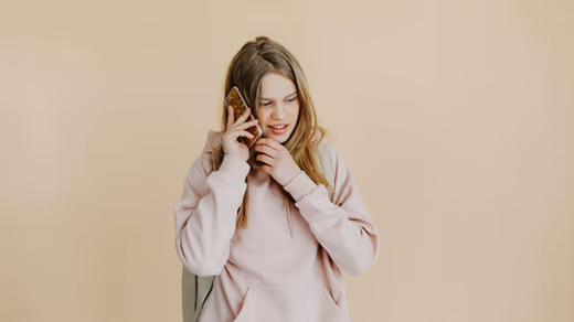 Young person sitting on a staircase at night, face lit only by phone glow.