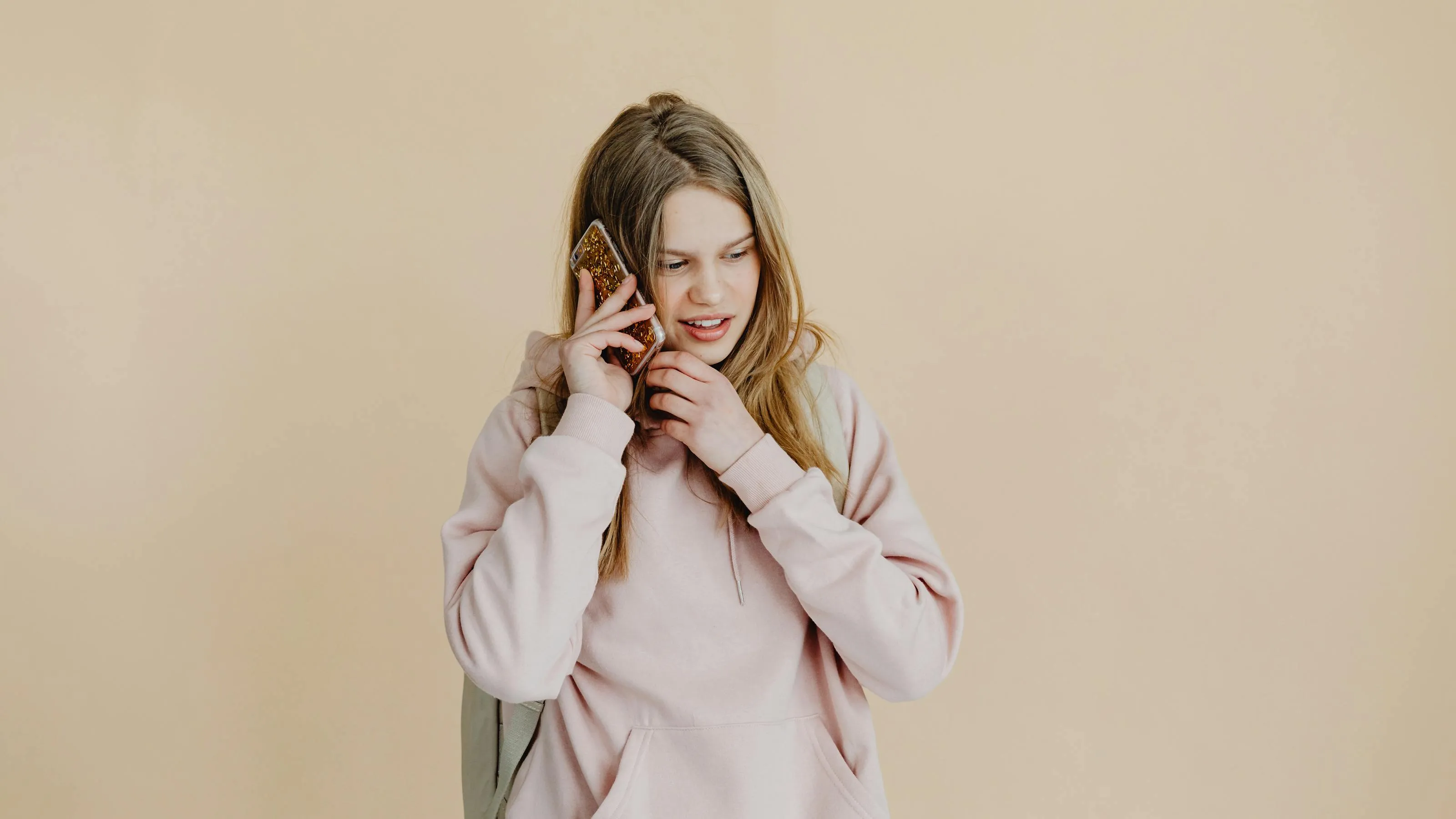 Young person sitting on a staircase at night, face lit only by phone glow.